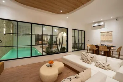 a living room with a white couch and a table at Leva Villa - Luxury 3BR Jimbaran in Jimbaran