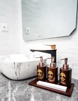 a bathroom with two soap dispensers next to a sink at Villa Maharani Sanur in Sanur