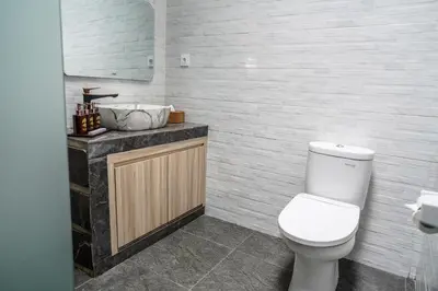 a bathroom with a white toilet and a sink at Villa Maharani Sanur in Sanur