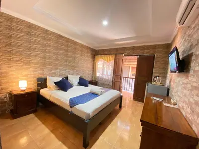 a bedroom with a bed and a flat screen tv at ABI Hotel3 - 1 minute to the Beach and 1 second to the Mall in Ngurah Rai International Airport