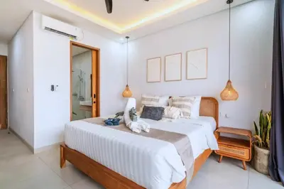 a bedroom with a large bed with white walls at Bimala 3 BR Private Pool Villa in Seminyak