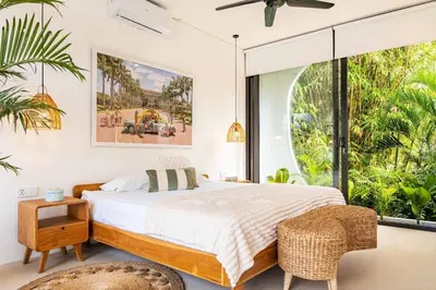 a bedroom with a bed and a large window at Tropical Chic Villa w Rooftop & Pool in Seminyak in Seminyak