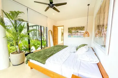 a bedroom with a bed and a large window at Tropical Chic Villa w Rooftop & Pool in Seminyak in Seminyak