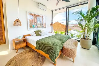 a bedroom with a bed and a large window at Tropical Chic Villa w Rooftop & Pool in Seminyak in Seminyak