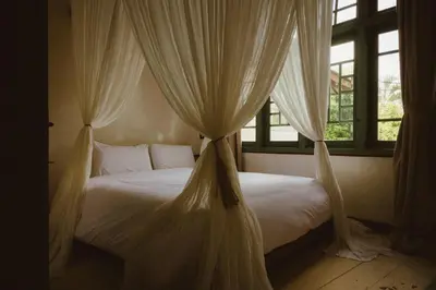 a bedroom with a bed with mosquito netting at Magia de Uma, a Member of Design Hotels in Canggu