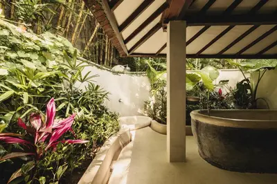 a garden with plants and a tub in a room at Magia de Uma, a Member of Design Hotels in Canggu