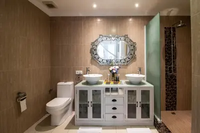 a bathroom with a sink and a toilet and a mirror at D Villa Seminyak in Seminyak