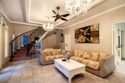 a living room with two couches and a chandelier at D Villa Seminyak in Seminyak
