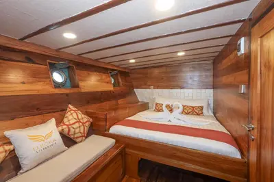 a small boat with a bed in the back of it at Boat Komodo in Seminyak
