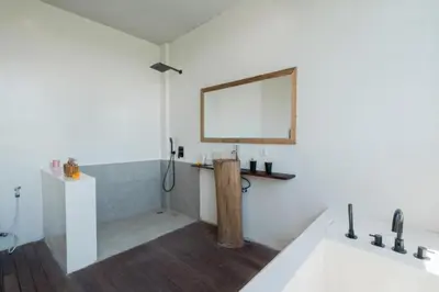 a bathroom with a tub and a sink and a mirror at Shankara 2 BR Private Pool Villa in Seminyak