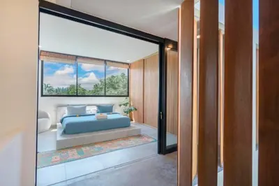 a bedroom with a blue bed and a large window at Shankara 2 BR Private Pool Villa in Seminyak