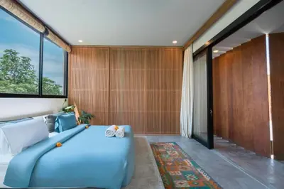 a bedroom with a blue bed and a large window at Shankara 2 BR Private Pool Villa in Seminyak
