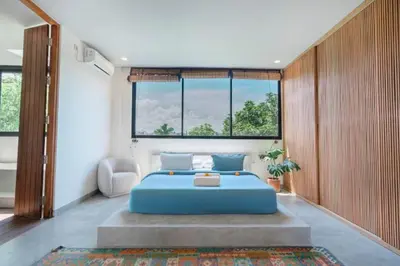 a bedroom with a blue bed and a large window at Shankara 2 BR Private Pool Villa in Seminyak