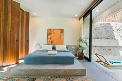 a bedroom with a blue bed and a bath tub at Shankara 2 BR Private Pool Villa in Seminyak