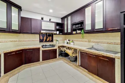 a kitchen with wooden cabinets and a sink at Balinese Home with Pool near Padma Beach, Legian in Legian