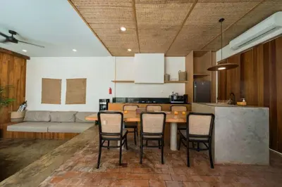 a kitchen with a table and chairs and a couch at Quilon 2 BR Private Pool Villa in Seminyak