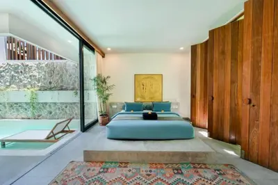 a bedroom with a large blue bed and a pool at Quilon 2 BR Private Pool Villa in Seminyak