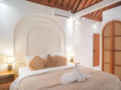 a white bedroom with a bed with a swan on it at Harbie Villa 1 in Seminyak
