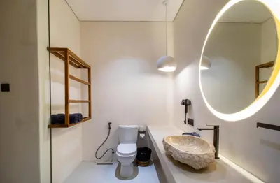 a bathroom with a stone sink and a mirror at Villa Lalalax 3BR Tropical Retreat in Jimbaran in Uluwatu