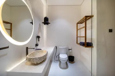 a bathroom with a sink and a toilet and a mirror at Villa Lalalax 3BR Tropical Retreat in Jimbaran in Uluwatu