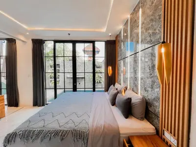 a bedroom with a large bed and a large window at Villa Diah in Seminyak