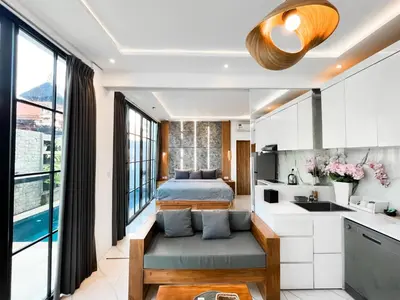 a kitchen and living room with a bed and a sink at Villa Diah in Seminyak