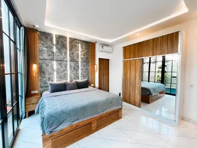 a bedroom with a bed and a large window at Villa Diah in Seminyak