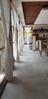 a long hallway with white curtains in a room at Bumahan Villa in Seminyak