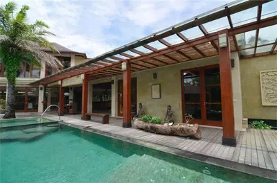 a house with a swimming pool in front of a building at Bumahan Villa in Seminyak