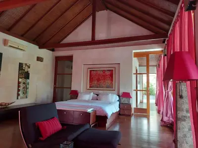 a bedroom with a bed and a couch at Bumahan Villa in Seminyak