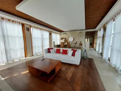 a living room with a white couch and red pillows at Bumahan Villa in Seminyak