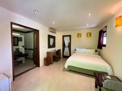 a bedroom with a large bed and a bathroom at Bumahan Villa in Seminyak