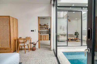 a bedroom with a bed and a dining room with a table at FYM LOVE VILLA Residence BALI in Kerobokan