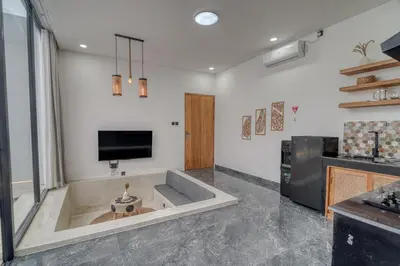 a large bathroom with a tub with a tv on the wall at FYM LOVE VILLA Residence BALI in Kerobokan