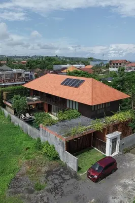 a red car parked in front of a house with a solar roof at Bali Radiance 4 bedrooms with private bathrooms - Pool, Beach & Airport in Ngurah Rai International Airport