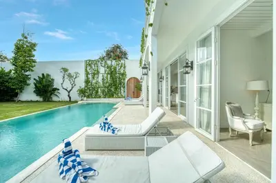 a living room with a pool and a house at Colonial House 4BR Villa With Ocean View in Berawa in Canggu