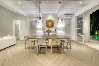 a dining room with a table and chairs and a couch at Colonial House 4BR Villa With Ocean View in Berawa in Canggu