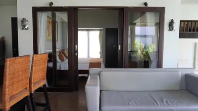 a living room with a couch and a bedroom at Tahoma Villas Seminyak by ABM in Seminyak