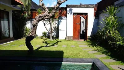 a front door of a house with a tree in the yard at Tahoma Villas Seminyak by ABM in Seminyak