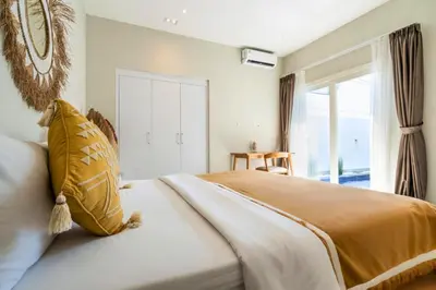 a bedroom with a large bed and a window at Ardelle 2 BR Private Pool Villa in Canggu