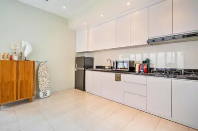 a kitchen with white cabinets and a refrigerator at Ardelle 2 BR Private Pool Villa in Canggu
