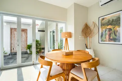 a dining room with a wooden table and chairs at Ardelle 2 BR Private Pool Villa in Canggu