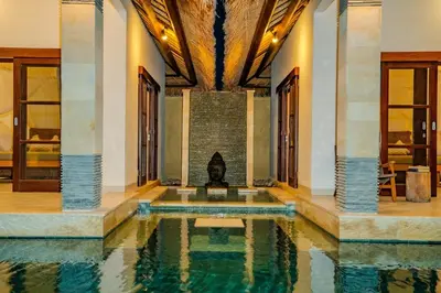 a swimming pool with a fireplace in a house at Villa Evelyne, Luxury Villa, Fully Staffed, Central Seminyak in Seminyak
