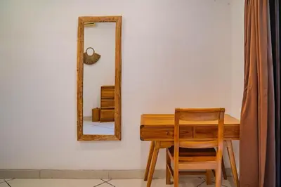 a wooden table with a mirror and a wooden chair at Villa Evelyne, Luxury Villa, Fully Staffed, Central Seminyak in Seminyak