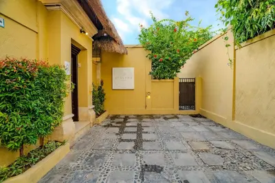 an alley with a yellow building and a tree at Villa Evelyne, Luxury Villa, Fully Staffed, Central Seminyak in Seminyak