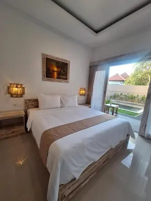 a bedroom with a large bed and a large window at Casa Benoa Homestay in Nusa Dua