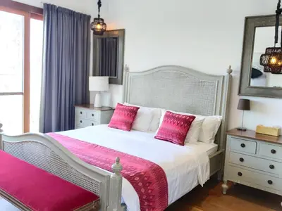a bedroom with a large white bed with pink pillows at Tropikal villa 2 bedrooms in seminyak Bali in Seminyak