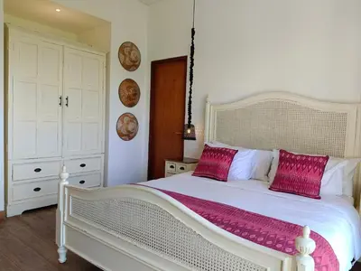 a bedroom with a large white bed with pink pillows at Tropikal villa 2 bedrooms in seminyak Bali in Seminyak