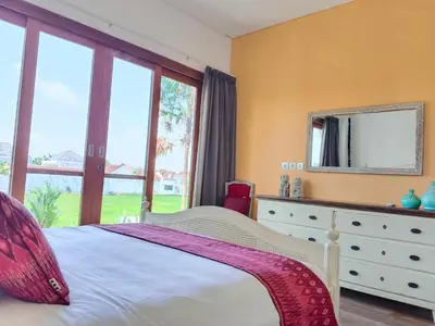 a bedroom with a bed and a dresser with a mirror at Tropikal villa 2 bedrooms in seminyak Bali in Seminyak