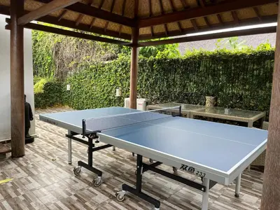 a ping pong table sitting under a gazebo at Villa Odil, Great Value 700m beach & 15m pool in Seminyak